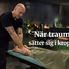 En man med tatueringar masserar en persons ben på en brits. Texten "När trauma sätter sig i kroppen" antyder en behandling för fysiska effekter av trauma.