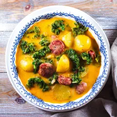 En värmande proteinrik soppa med korv, potatis och grönkål i en krämig buljong.