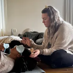 En kvinna leder en breathwork utbildning. Deltagare ligger på golvet med sovmaskar, redo att utforska andningens kraft.