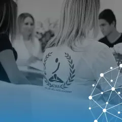 Personer samlade för fascia utbildning. En person bär en t-shirt med logotypen för Keller Wellness Academy.