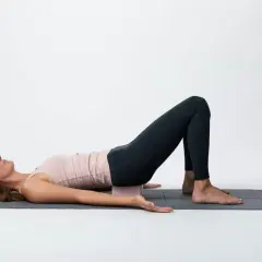 Kvinna i brygga med block under svanskotan, en lugnande position som kan stödja **yin yoga viktminskning** genom avslappning och stressreducering.
