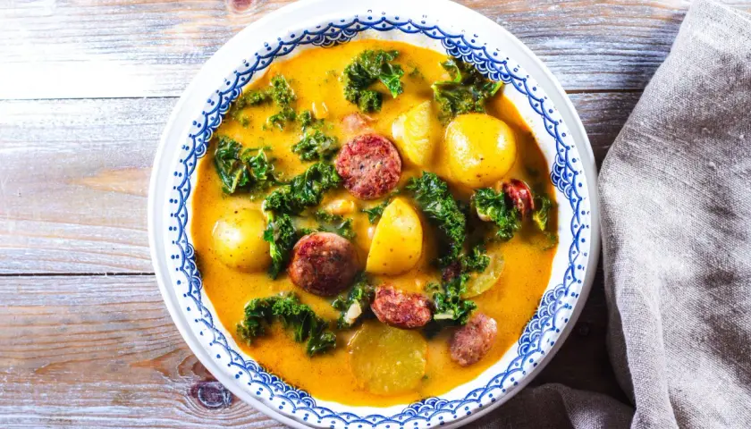 En värmande proteinrik soppa med korv, potatis och grönkål i en krämig buljong.