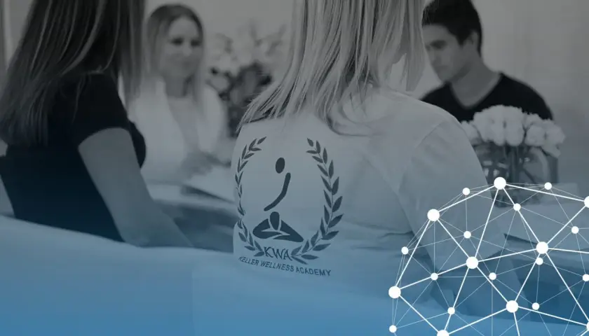 Personer samlade för fascia utbildning. En person bär en t-shirt med logotypen för Keller Wellness Academy.