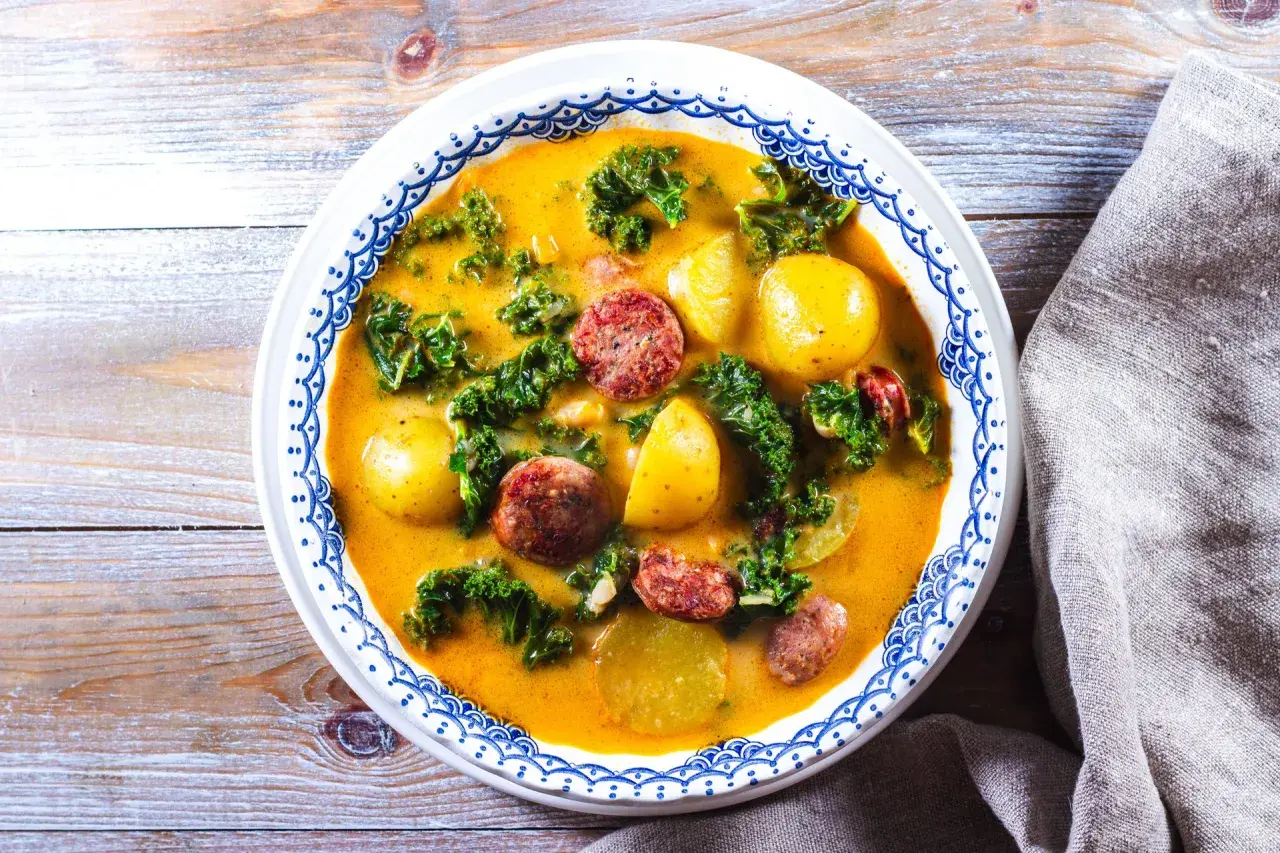 En värmande proteinrik soppa med korv, potatis och grönkål i en krämig buljong.