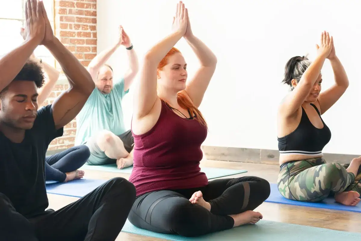 Människor sitter i lotusställning på yogamattor, en del av en resa mot yin yoga viktminskning.