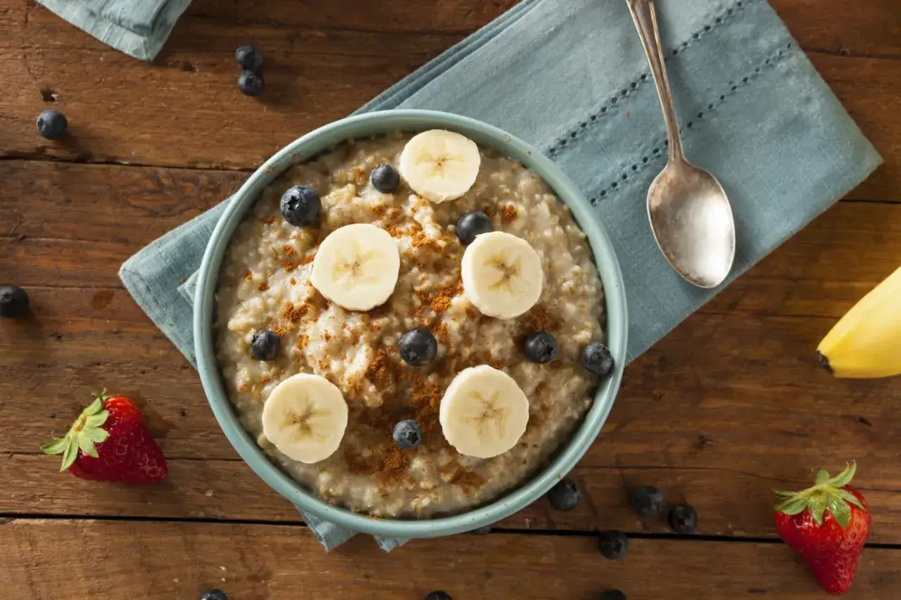 En skål med havregrynsgröt toppad med banan, blåbär och kanel. En perfekt bra frukost klimakteriet för en energifylld start på dagen.