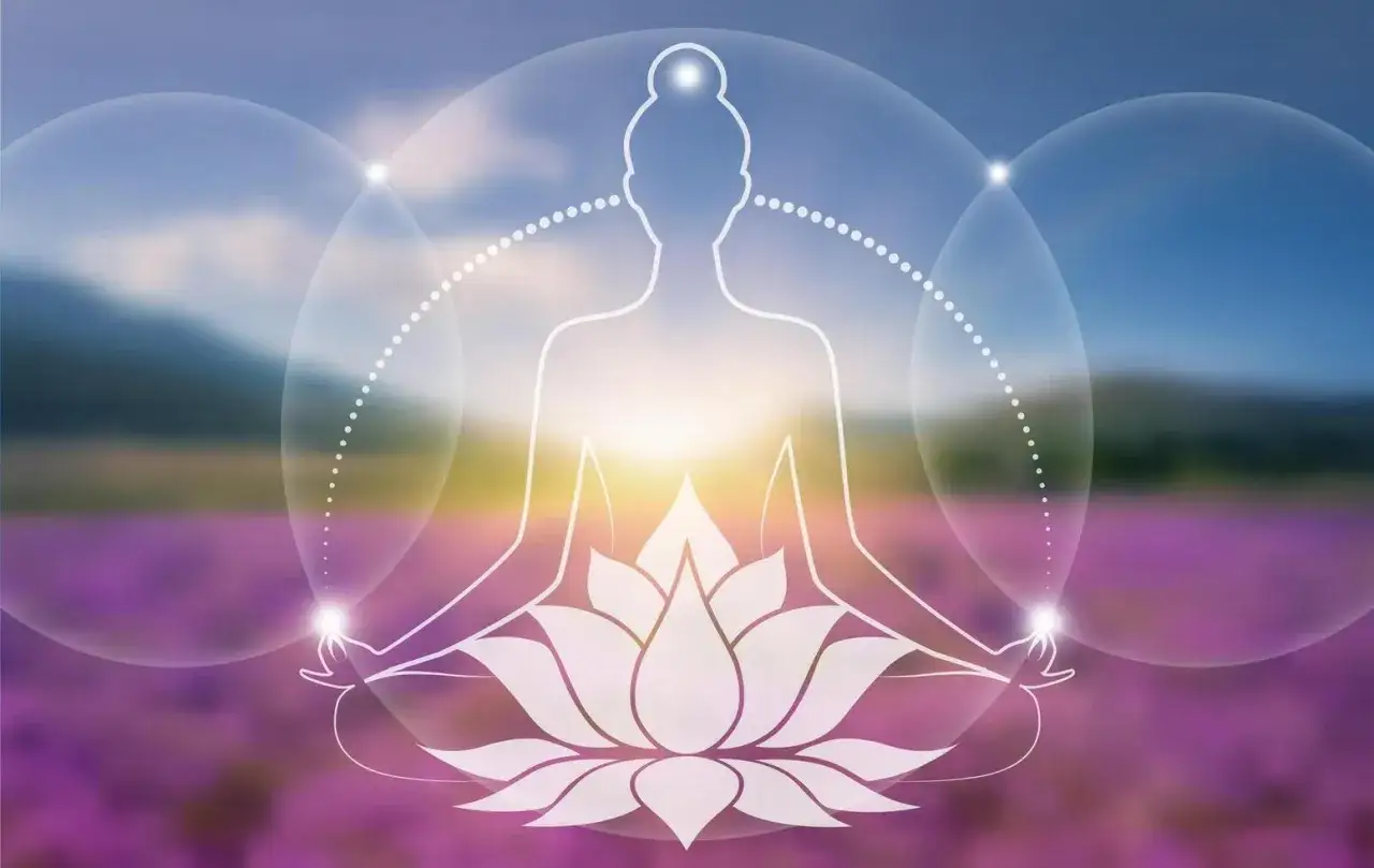 En person i meditationsst&auml;llning med en yoga blomma under sig. Bakgrunden &auml;r en suddig bild av ett f&auml;lt med lila blommor och en solnedg&aring;ng.